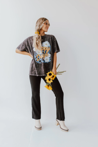 Flare jeans paired with an oversized graphic tee shirt that reads Happy Days